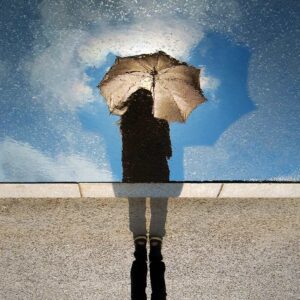 Woman with an umbrella on her way to cognitive behavioral therapy port jefferson, new york