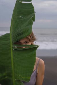 A woman hiding behind a leaf because she is looking for a cbt therapist near me