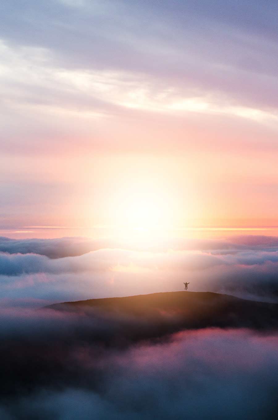 A man stands on a misty hill surrounded by fog and illustrating a peaceful scene