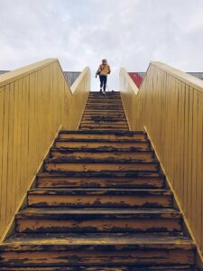 A woman walking up the stairs to her appointment with a CBT therapist for trauma