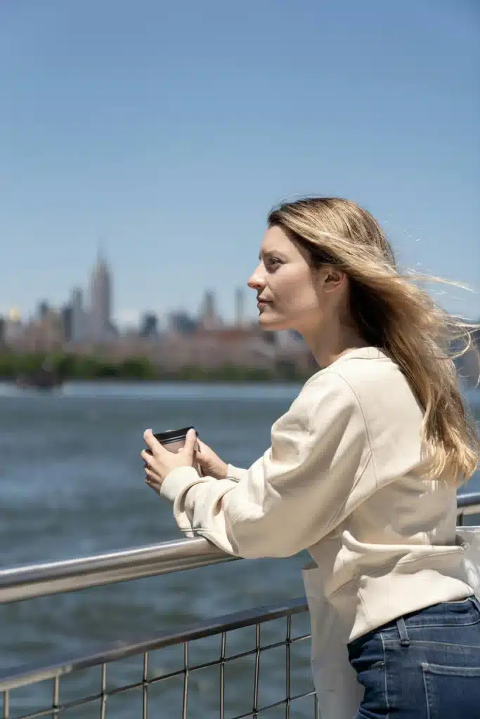 Woman sitting peacefully on boat looking at water finding relief from anxiety through CBT therapy in Long Island New York