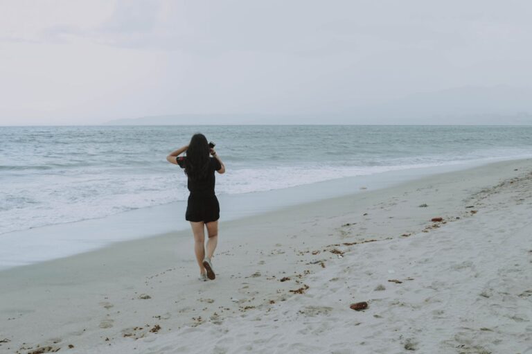 Person walking alone along a quiet beach, reflecting on anxiety and emotional healing through therapy