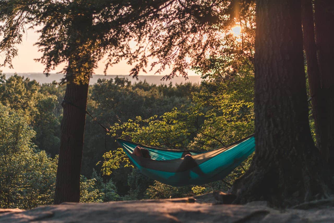 Person relaxing in a hammock outdoors, representing mindfulness-based stress reduction and CBT techniques for mental health