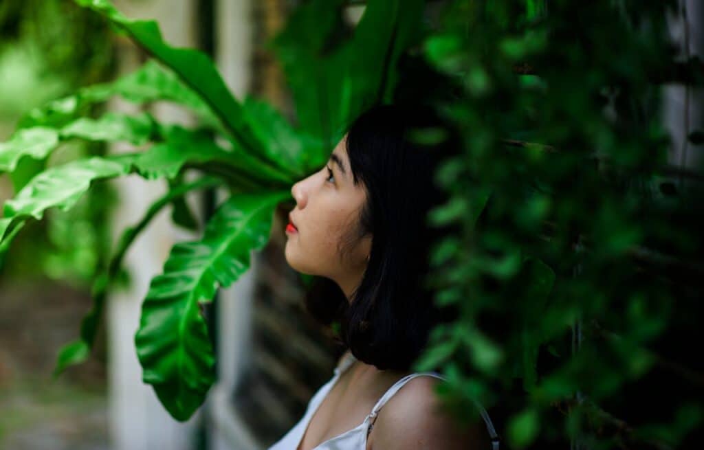 Person reflecting quietly among greenery, representing emotional healing through cognitive behavioral therapy