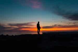 Person standing at sunset representing progress and resilience through CBT for anxiety