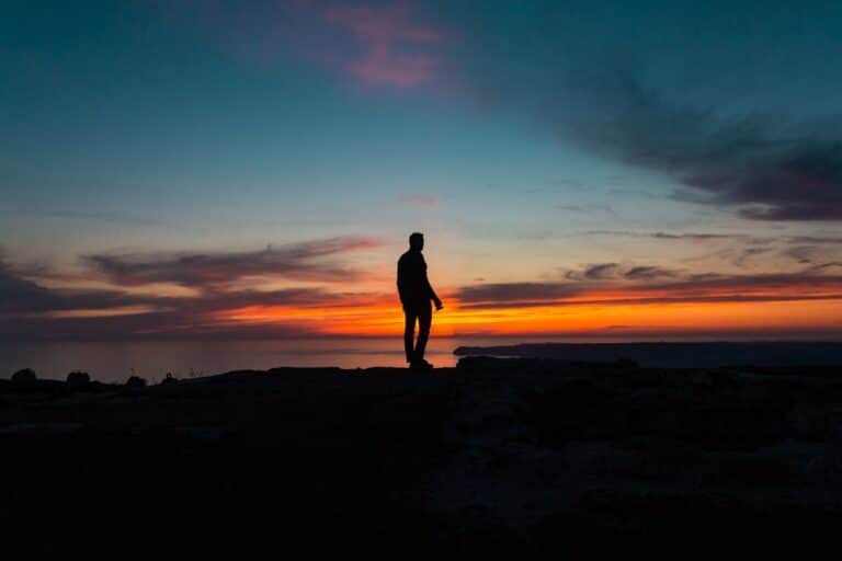 Person standing at sunset representing progress and resilience through CBT for anxiety