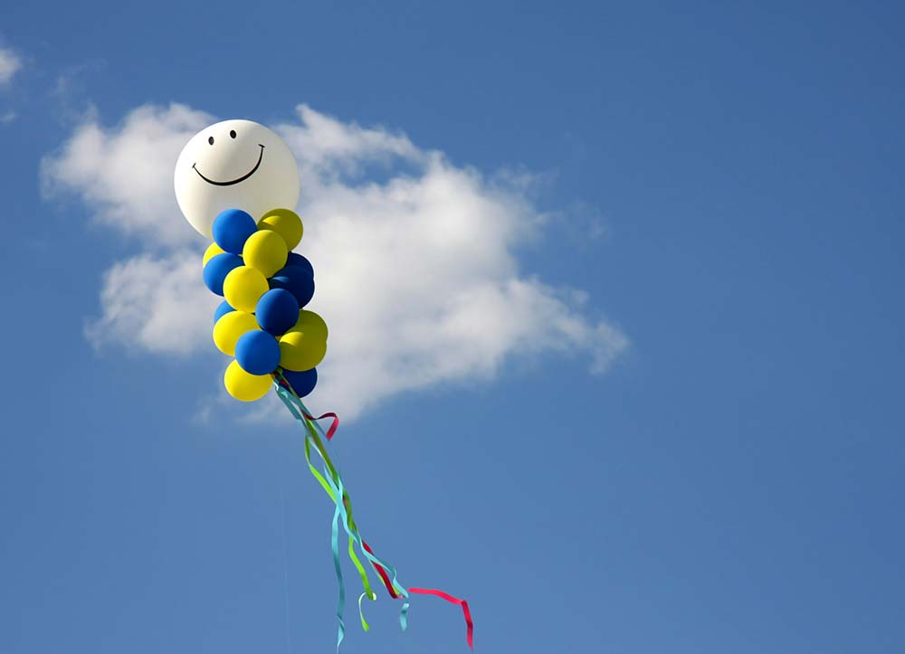 a kite flying in the sky with a smiley face on it